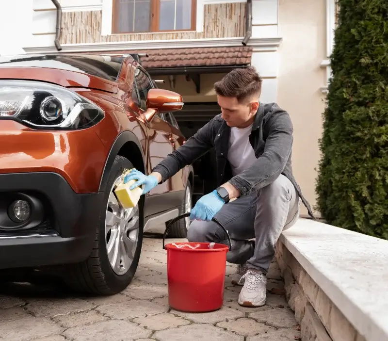 Lavage auto à domicile Gudas : professionnel intervenant sur un véhicule